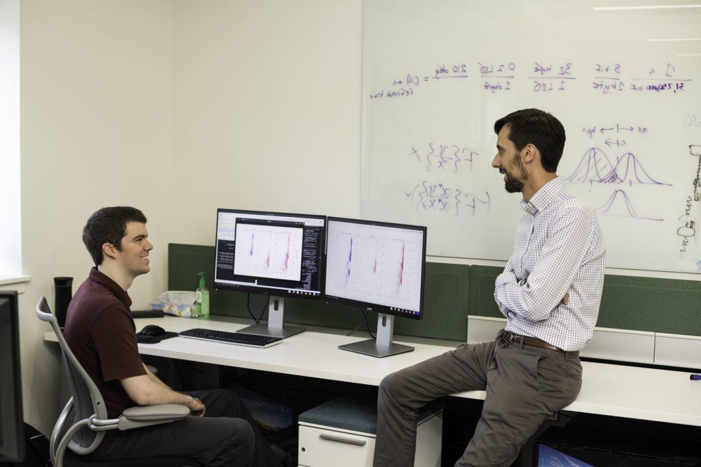 学生和教授在计算机实验室里看着数据集